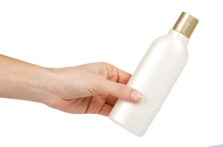 White plastic shampoo bottle in hand. Isolated on white background. Bathroom gel for body care. Blank template.の写真素材
