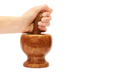 female hand uses a stone mortar to prepare spices. Isolated on white background.の写真素材