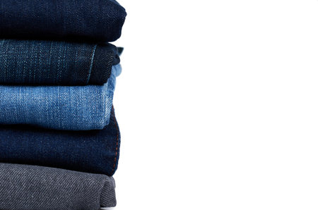 Foldet jeans in pile, isolated on white background, copy space.の写真素材