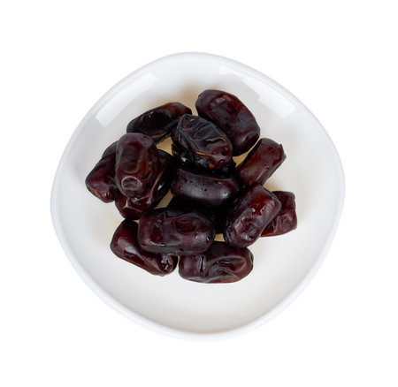 Dried dates on plate isolated on white background.