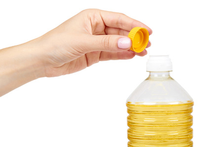 vegetable or sunflower oil in plastic bottle with hand isolated on white background.の写真素材