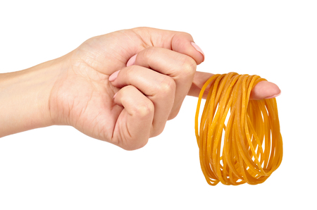 Yellow rubber bands close up with hand isolated on white backgroundの写真素材