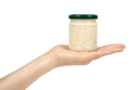 Creamy sauce with truffle for pasta in glass jar isolated on white background, with hand.の写真素材