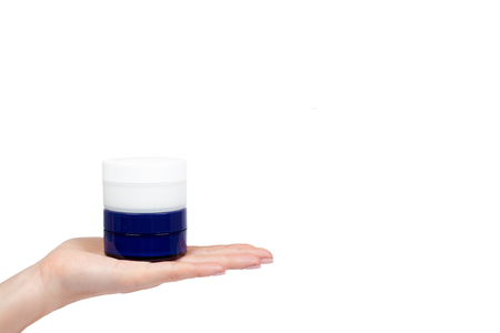 Clean cream bottle with hand isolated on white background, copy space template.の写真素材