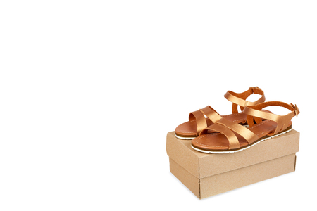 Golden color eco leather sandals with box isolated on white background, copy space template.の写真素材