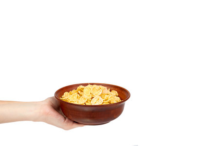 bowl of corn flakes with hand isolated on white background, copy space template.
