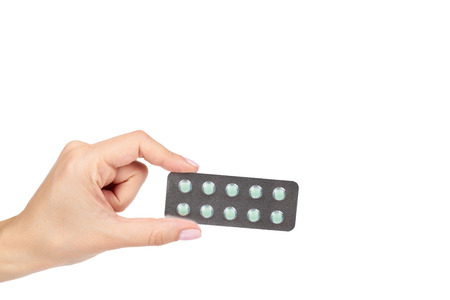 Silver blister packs pills with hand isolated on white background, copy space template.の写真素材