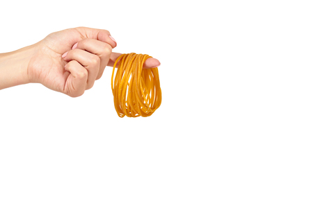 Yellow rubber bands close up with hand isolated on white background, copy space template.の写真素材