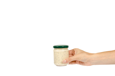 Creamy sauce with truffle for pasta in glass jar isolated on white background, with hand, copy space template.の写真素材