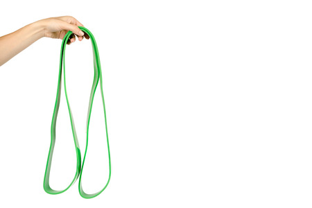 Green resistance band with hand for fitness sport, isolated on white background, copy space template.の写真素材