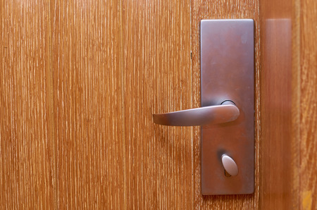 metal lock with a handle on a closed wooden door.の写真素材