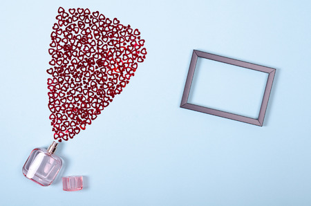 Flat lay arrangement of hearts and perfume bottle for mock up design, table top view image of decoration valentine's day background concept for post cardの写真素材