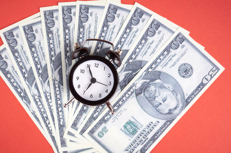 US dollars with clock on red background composition, flat lay and top view photo