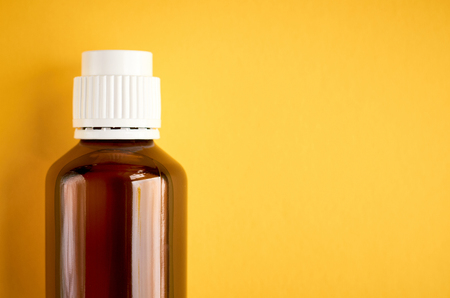 Syrup in glass bottle composition on yellow background, flat lay and top view photoの写真素材