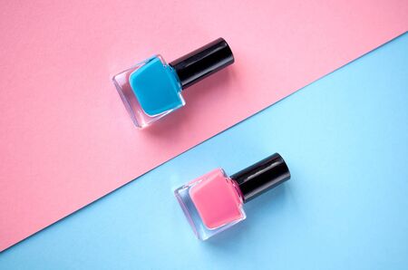 Color nail polish bottles on pink background composition. Flat lay and top view photoの写真素材