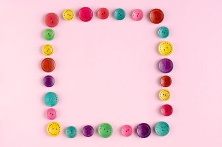 Colored sewing buttons composition on pink background. Flat lay, layout and tabletop mockup with copy space.の写真素材