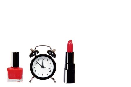 Red nail polish, lipstock and alarm clock. Isolated on white background. Copy space template.の写真素材