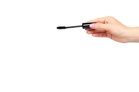 Hand with black mascara, eye makeup brush. Isolated on white background. Copy space template.の写真素材