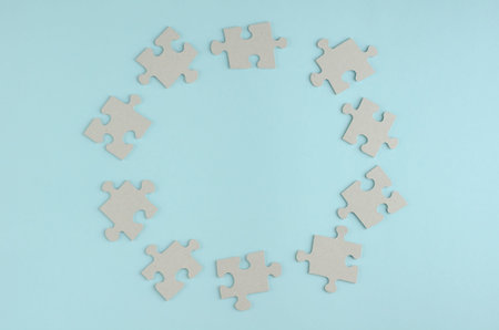 Gray puzzles composition on blue background. Flat lay, layout and tabletop mockup with copy space.