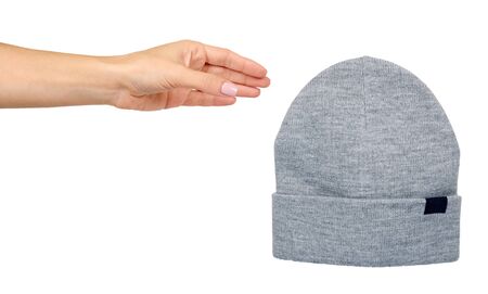 Hand with gray cotton hat. Winter season apparel, cport wear. Isolated on white background.の写真素材