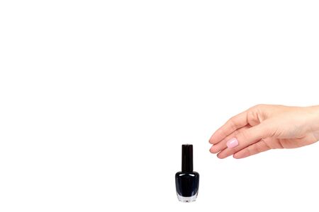 Hand with black nail polish bottle, beauty and care. Isolated on white background. Copy space template.の写真素材