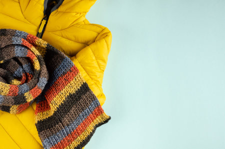 Yellow kids winter jacket composition on blue background. Flat lay, layout and tabletop mockup with...