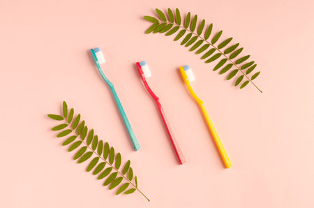 Colored toothbrushes composition on pink background. Flat lay, layout and tabletop mockup with copy...