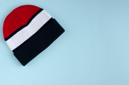 Striped colored hat composition on blue background. Flat lay, layout and tabletop mockup with copy...