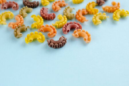 Colored pasta composition on blue background. Flat lay, layout and tabletop mockup with copy space.の写真素材