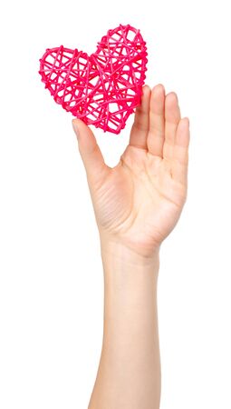 Hand with pink wooden heart, handmade gift. Isolated on white background.の写真素材