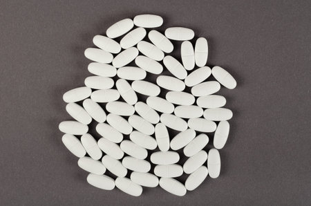 White medical pills composition on dark background. Flat lay, layout and tabletop mockup with copy space.の写真素材