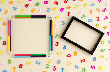 Colored wooden numbers composition on beige background. Flat lay, layout and tabletop mockup with...