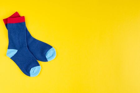 Cotton kids socks composition on yellow background. Flat lay, layout and tabletop mockup with copy space.の写真素材