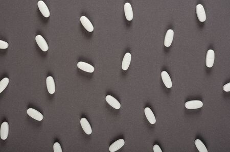 White medical pills composition on dark background. Flat lay, layout and tabletop mockup with copy space.の写真素材