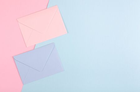 Blue paper envelope composition on pink background. Flat lay, layout and tabletop mockup with copy space.の写真素材