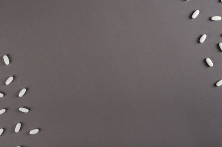 White medical pills composition on dark background. Flat lay, layout and tabletop mockup with copy space.の写真素材