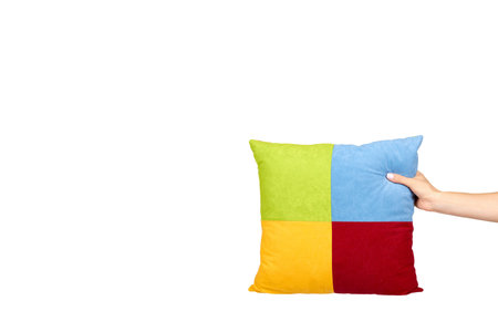 Hand with decorative square pillow, multicolored cloth, soft and puffy. Isolated on white background. Copy space template, mockup.の写真素材