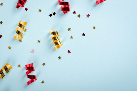 Colored confetti composition on blue background, party and celebration decoration. Flat lay, layout...