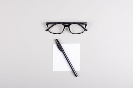 Black pen and note composition on gray background. Flat lay, layout and table top mockup with copy space.の写真素材