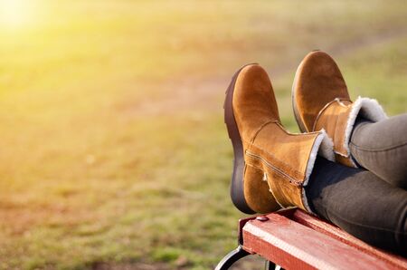 Girls legs in brown shoes lie on a wooden bench. Sunshine.の写真素材