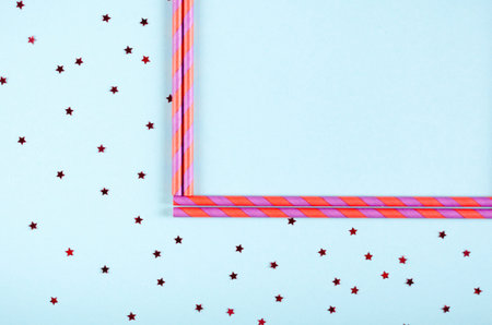 Pink frame from straw composition on blue background, party and celebration decoration. Flat lay,...