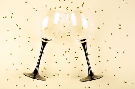 Wineglasses with confetti composition on biege background. Flat lay, layout and tabletop mockup with copy space.の写真素材