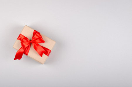 Gift box on gray background composition, present with ribbon and bow. Flat lay and top view photo...