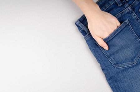 Blue cotton jeans texture and hand background with copy space. Top view photo.