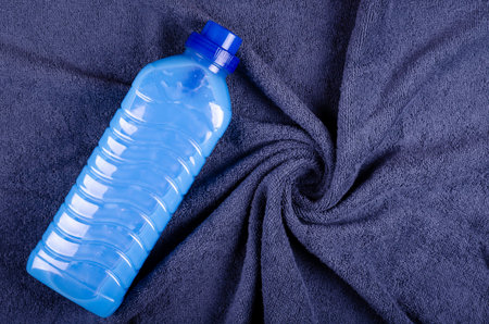 Blue conditioner in bottle on textile composition. Flat lay and top view photo with copy space.の写真素材