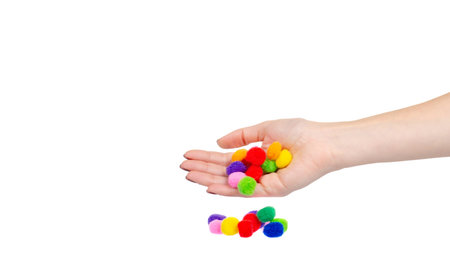 Hand with colored pom pom, party and sewing decoration. Isolated on white background. Copy space, template.の写真素材