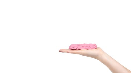 Hand with pink chocolate bar, strawberry candy. Isolated on white background. Copy space, template.の写真素材