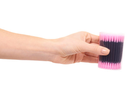 Hand with black and pink ear stick cleaner. Isolated on white backgorund.