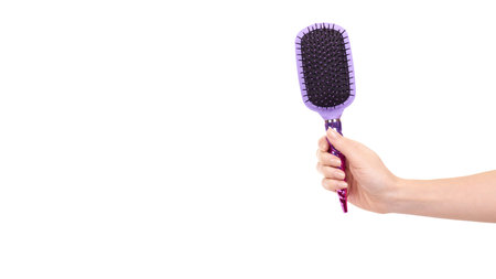 Hand with purple hairbrush, hair care and beauty. Isolated on white background. Copy space, template.の写真素材