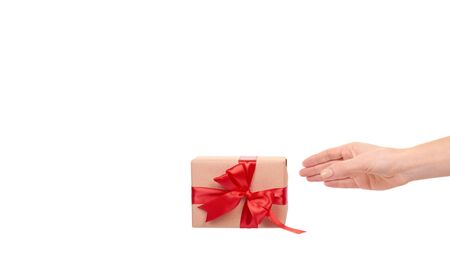 Hand with gift box, wrapped with brown paper. Isolated on white background. Copy space, template.の写真素材